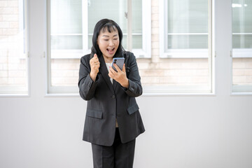 スマホを見て喜ぶビジネスウーマン