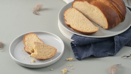 Naklejka premium Sliced Folar de Olhão Sweet Bread on Ceramic Plates with Blue Linen