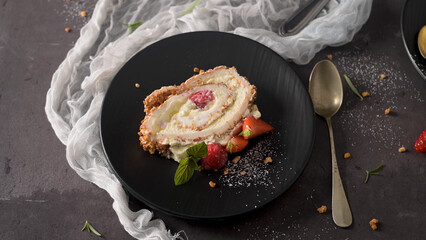 Slice of Berry Meringue Roulade with Fresh Raspberries and Mint