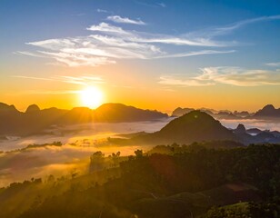 Aerial view captures a dawn sunrise over misty mountains and lush, green forests, with a vibrant sky filled with clouds