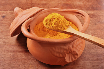 Dry curry powder in bowl on wooden table