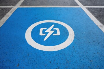 Blue parking spot painted with electric vehicle charging symbol