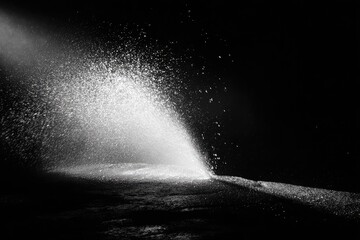 Powerful stream of water erupting from a dark surface