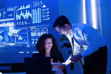 Business team collaborates on data analysis in modern office setting during evening meeting