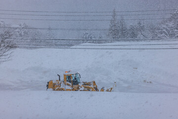 積雪した道路で行われる早朝の除雪作業