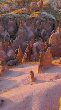 Vertical video. Goreme, Nevsehir, Turkey. Fantasy landscape of Devrent Valley with alien-like rock formations and surreal colors during evening hours.. Aerial View, Point of interest. Rich colors