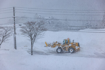 積雪した道路で行われる早朝の除雪作業