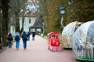 Charming red train near transparent domes and trees on a pathway © Iurii Gagarin