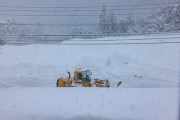 積雪した道路で行われる早朝の除雪作業