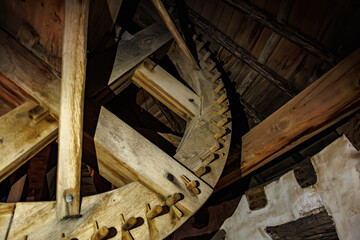 Close-up of antique wooden gear mechanism in rustic building, windmill © Iurii Gagarin