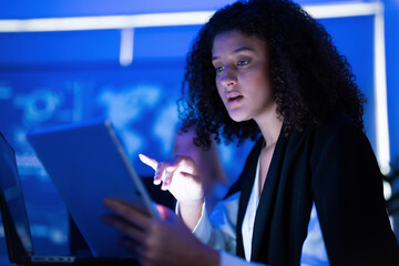 Young woman engaged in digital analysis in a modern workspace during evening hours