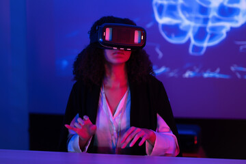 Young woman explores virtual reality in a dimly lit room with colorful lighting and digital projections