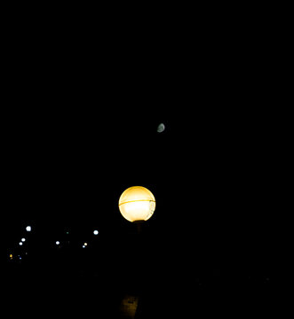 Contrast between a street light and the moon