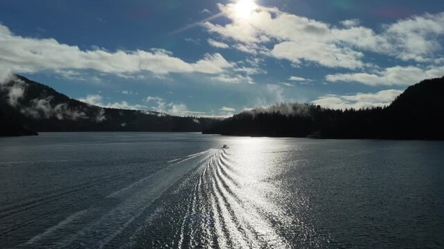 Boat sails towards Vancouver Island under bright sky at Samson narrows