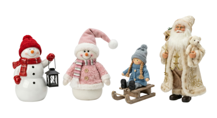 Collection of festive holiday figures including snowmen Santa and a girl on sledge isolated on