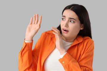 Scared young woman on light background