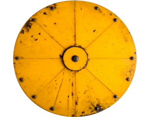 A close-up view of a circular, aged, yellow object with dark bolts and lines radiating from the center