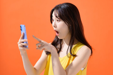 スマホを持って驚く女性