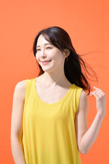 オレンジ背景　ミドル女性　ポートレート