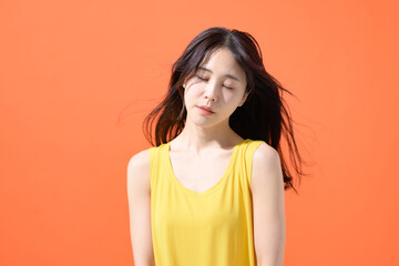 オレンジ背景　ミドル女性　ポートレート