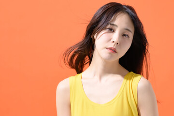オレンジ背景　女性　ポートレート
