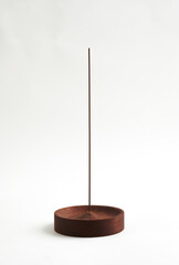 Minimalist wooden incense holder with incense stick on white background