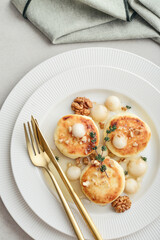 cottage cheese pancakes, syrniki, curd fritters served with pear balls, walnut and honey