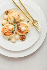 cottage cheese pancakes, syrniki, curd fritters served with pear balls, walnut and honey