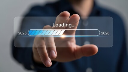 Close-up of a hand touching a futuristic digital screen displaying a loading bar transitioning from 2025 to 2026, symbolizing progress and future.