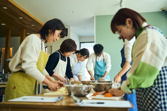 料理教室で調理を学ぶ人々