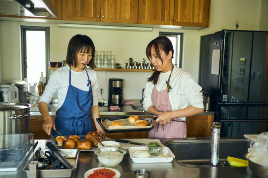 キッチンで焼き上がった手作りパンを確認する女性達