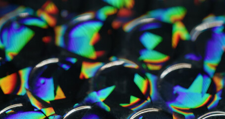 Defocused glow rainbow. Colorful light. Orange blue green round reflection gleam texture leak on abstract dark black art background.