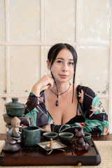 Meditation ceremony. Spiritual practice. Pensive female enjoying calming atmosphere with glass tea-board incense placed on table.