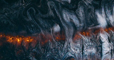 Glitter wave. Paint lava. Black ash shimmering emulsion spill on wet gray background. Hot orange glow line abstract blur volcanic.