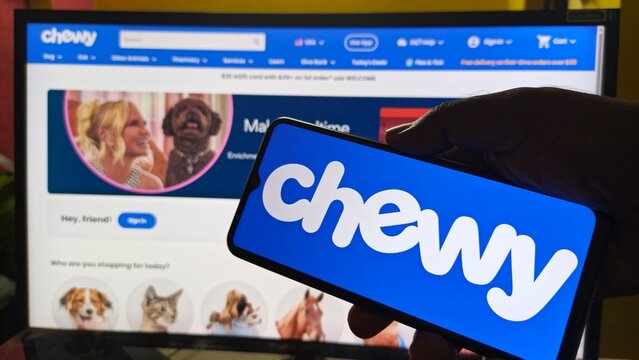 Chewy ecommerce website and mobile app logo displayed on screen and smartphone