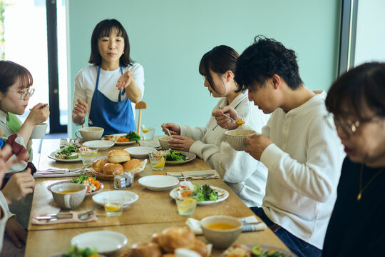 料理教室の後作った料理を囲んんで食事を楽しむ人々