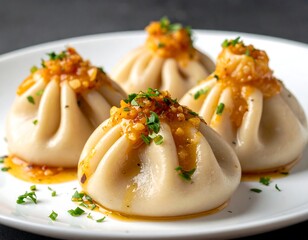 Close-up of four steamed dumplings with savory sauce and garnish