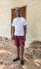 village happy african man portrait, outdoors in the nature ,stone wall with door behind