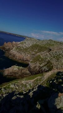 Pointe du Raz, Brittany, France - Jagged Rocky Cliffs Stretch Along the Coastline, Dropping Sharply Into the Deep Blue Sea Beneath a Clear Sky - Vertical Shot