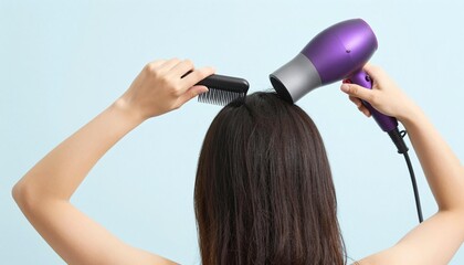 Woman drying long dark hair with a purple hair dryer and comb against a pale blue background