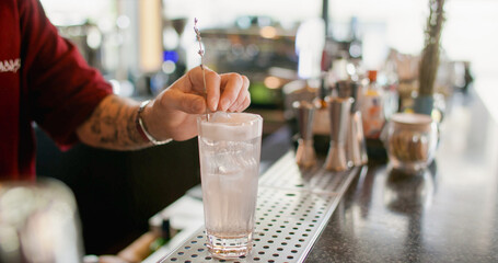 Preparing beverage. Cold drink. Barman hand decorating ice cube water with whipped white cream. Tall glass sweet lavender sprig flavor.