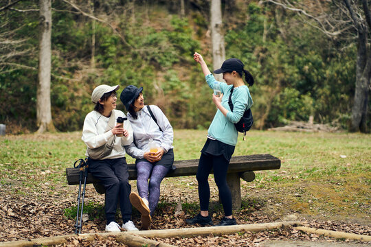 自然の中で休憩しながら会話を楽しむ女性達