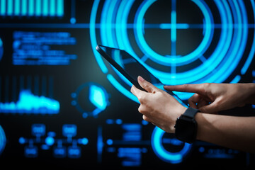 Woman holding tablet computer with futuristic blue data dashboard background, digital analytics, smart technology, data visualization, business intelligence, advanced user interface design.