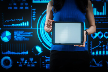 Woman holding tablet computer with futuristic blue data dashboard background, digital analytics, smart technology, data visualization, business intelligence, advanced user interface design.
