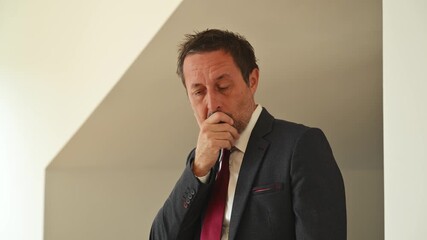 Stressed businessman touching his forehead, symbolic of burnout, pressure, and corporate failure. Conceptual image of executive in despair, representing business challenges and emotional struggle. 4K.