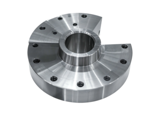 A close-up view of a precision-machined, metallic component. It has circular design with a protruding central cylinder and drilled holes