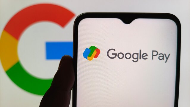 Smartphone displaying google pay app interface with google logo in background