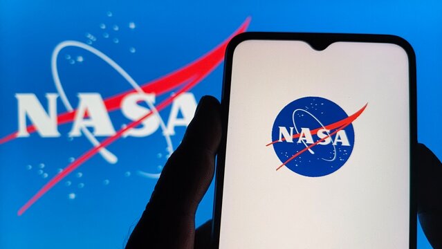 Smartphone displaying nasa logo in front of a large nasa logo background