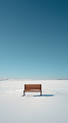 Single wooden bench in a snowy landscape under a clear blue sky, creating a peaceful and solitary scene, isolated with copy space, vertical 9:16 composition