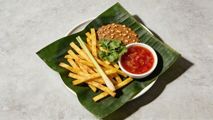 Thai-Style Crispy French Fries with Peanut Sauce and Chili Sauce, Served on Banana Leaf (Asian Savory Snack)